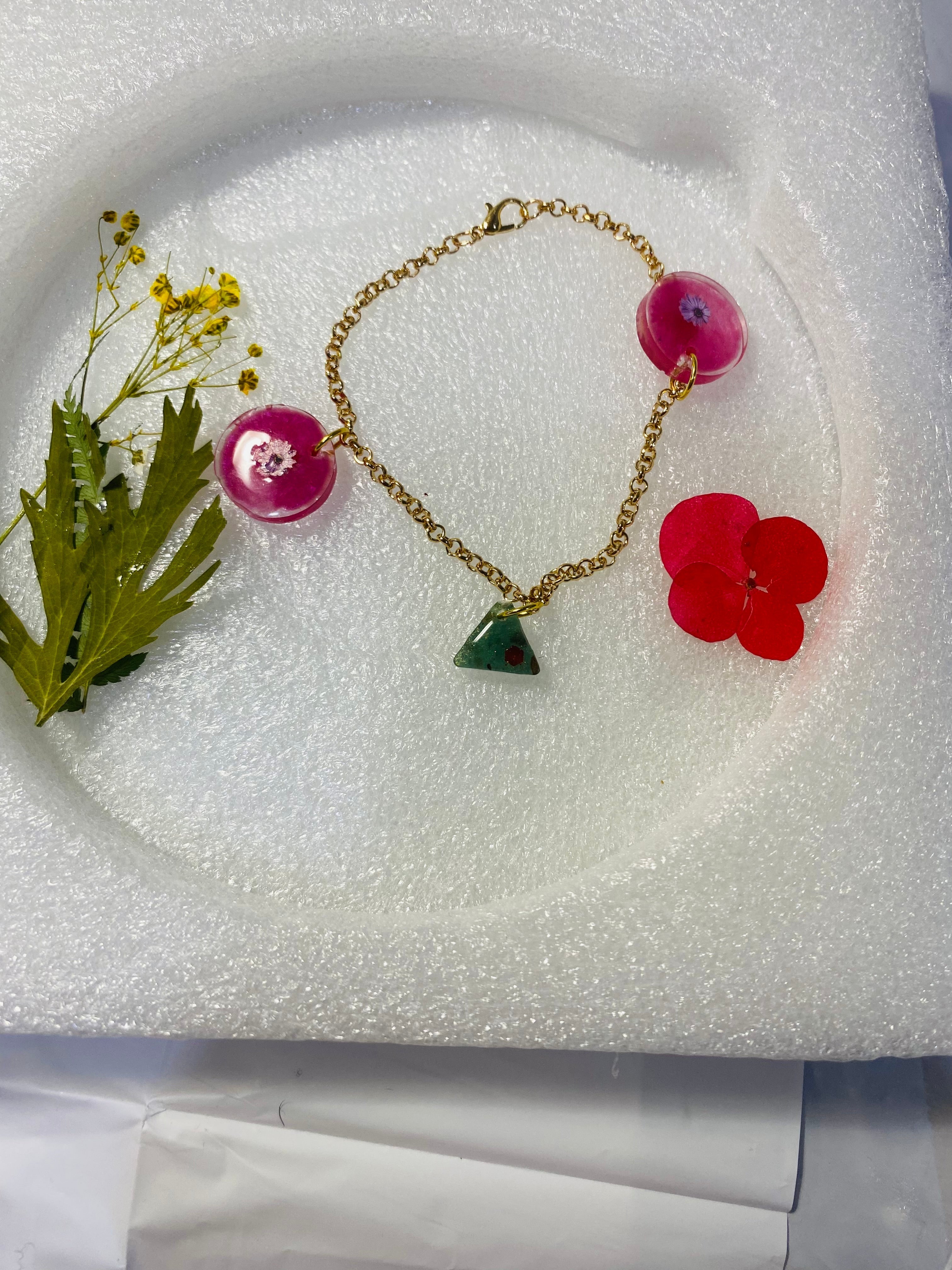 Pulsera Artesanal con dijes de manitas y pies de bebé.