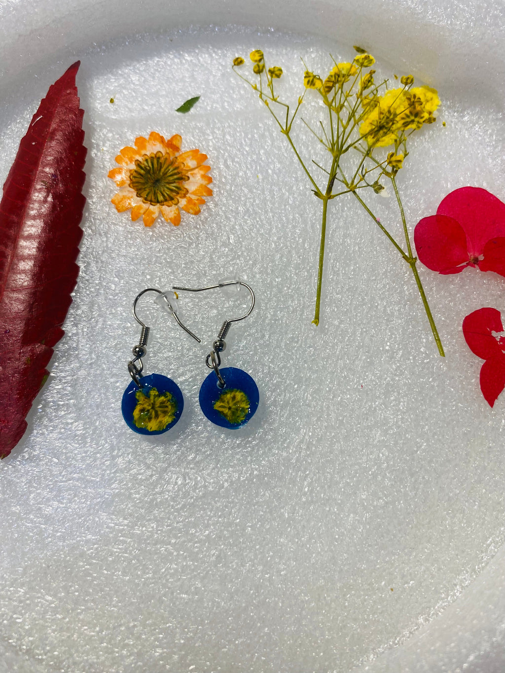 Aretes artesanales de resina y flor natural.